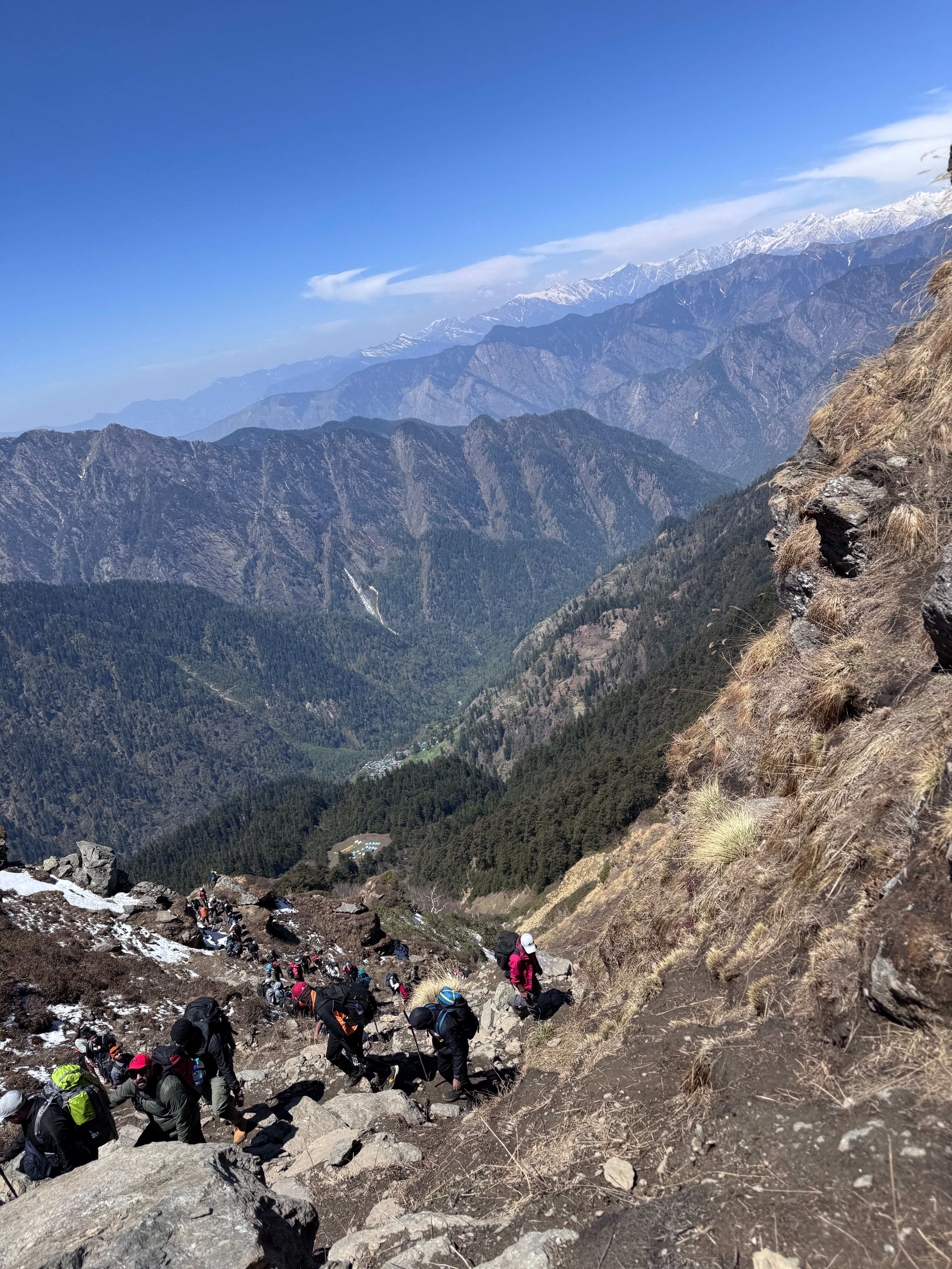 A group of hikers crossing a snowy mountain slope